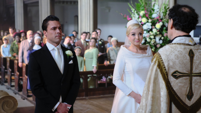  Olly Rix într-o rochie de dimineață și Helen George într-o rochie de mireasă stau în fața unui vicar în biserica din Call the Moafe.