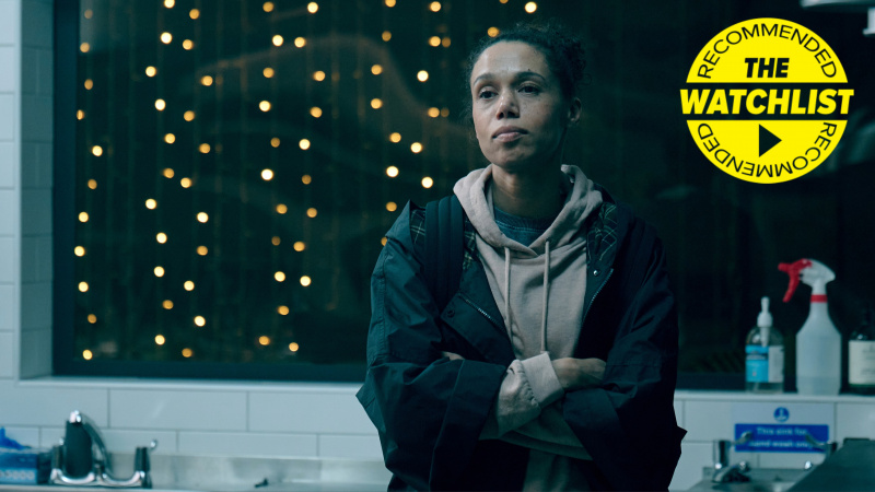   Carly (Vinette Robinson) so skríženými rukami stojí v kuchyni v bode Boiling Point a v rohu je náš žltý odznak Odporúčaný zoznam sledovaných osôb