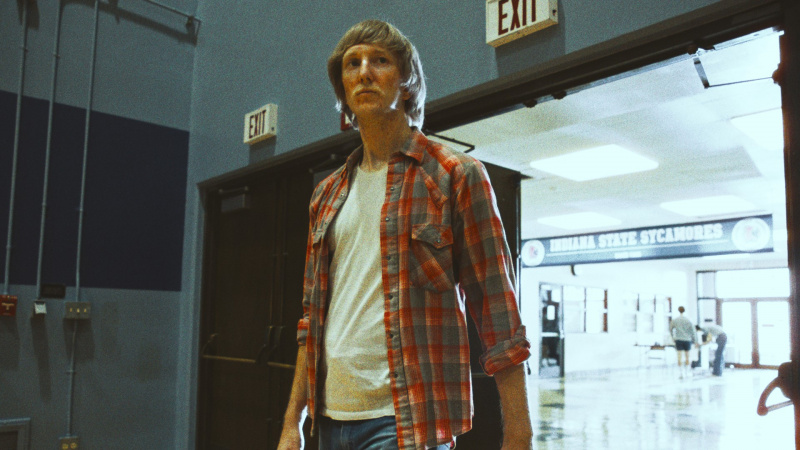   Sean Patrick Small als Larry Bird, der in Episode 3 der zweiten Staffel von Winning Time in Jeans den Basketballplatz betritt