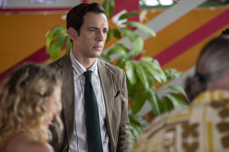   Neville (Ralf Little) se tient devant les suspects – on peut voir Petra (Leah Brotherhead) et Ivan (Pearce Quigley) au premier plan, dos à la caméra.