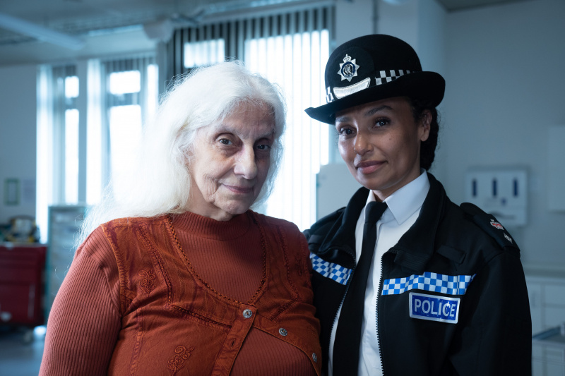   Ella (Souad Faress) steht mit ihrer Enkelin, Chief Superintendent Charlie Woods (Jade Harrison), auf der Krankenstation. Beide lächeln schwach in die Kamera.