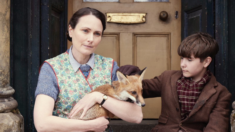   Anna Madeley ako pani Hallová sedí na schode a drží líšku ako Owen Phillips ako Christopher Taylor vo vianočnom špeciáli All Creatures Great and Small 2024.