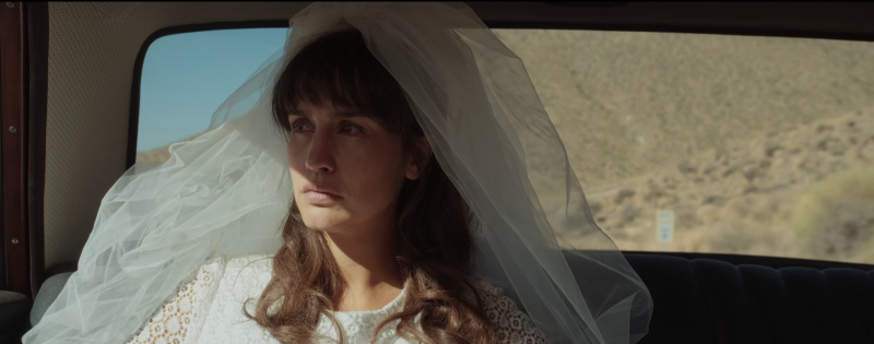 María con un velo mirando por la ventana del auto en el episodio 1 de Between Lands.