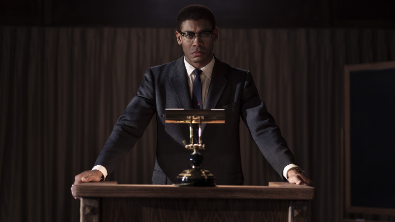   Aaron Pierre รับบทเป็น Malcolm X ด้านหลังโพเดียมใน Genius: MLK/X ตอนที่ 4