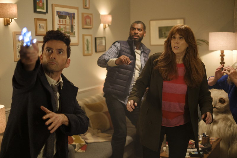   Doktor (David Tennant), sonik tornavidayı Donna'daki tavana doğrultuyor's living room, while Shaun (Karl Collins), Donna (Catherine Tate), Sylvia (Jacqueline King) and the Meep step back