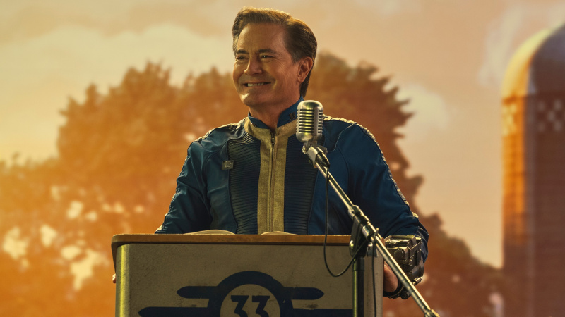   Nadzornik Hank MacLean (Kyle MacLachlan) u svom trezorskom odijelu stoji na podiju u Falloutu.
