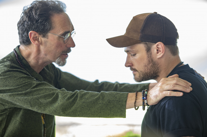   Ray (Guy Henry) stoji nasuprot svom sinu Maxu (Mark Strepan). Ray je uhvatio Maxa u ruke's shoulders, implying he is trying to reason with him