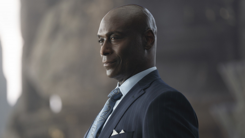   Lance Reddick u crnom odijelu kao Zeus u Percy Jackson & The Olympians