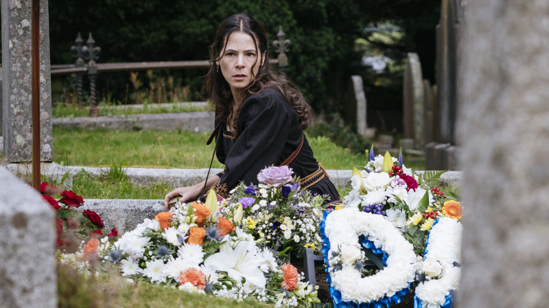 Elaine Cassidy kui Sarah Fenn istub Sanctuary: A Witch kalmistul lillede vahel's Tale