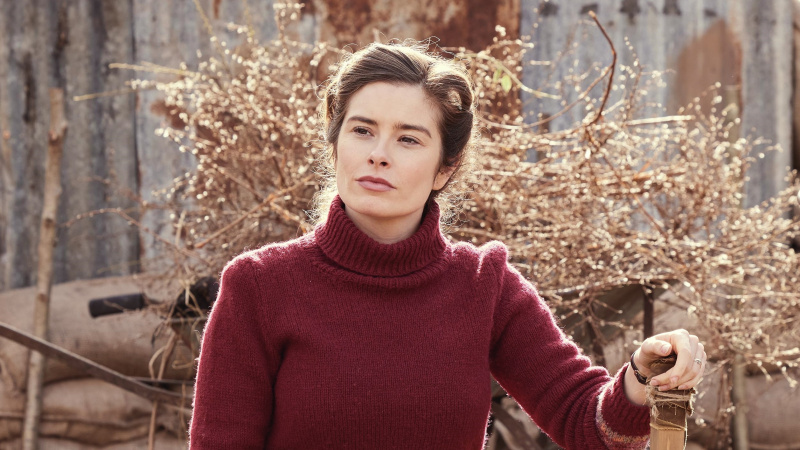   Rachel Shenton v červenom svetre vonku ako Helen vo filme Všetky veľké a malé stvorenia.