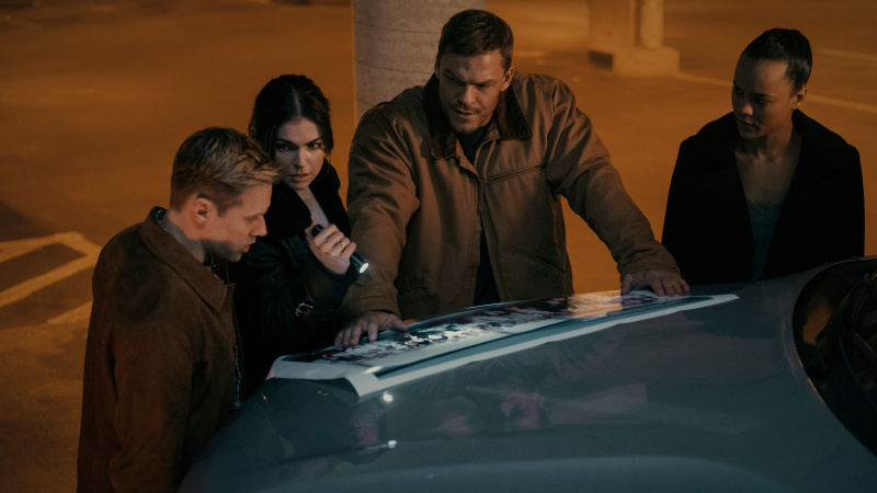   Ο Reacher και τα άλλα 110 μέλη βλέπουν μια φωτογραφία προσωπικού στο καπό ενός SUV στο επεισόδιο 3 της σεζόν 2 του Reacher.