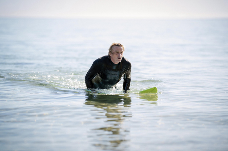  Sean (Peter O.'Brien) out in the ocean, lying on his surfboard, wearing a wetsuit