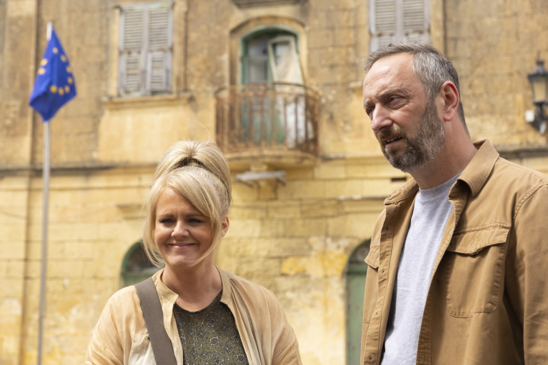  Jean (Sally Lindsay) et Dom (Steve Edge) se tiennent dehors dans la rue Sainte Victoire