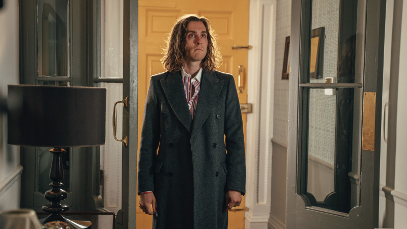   Jack Farthing, Rain Dogs'ta bir palto ve çizgili gömlekle koridorda duran Selby rolünde.