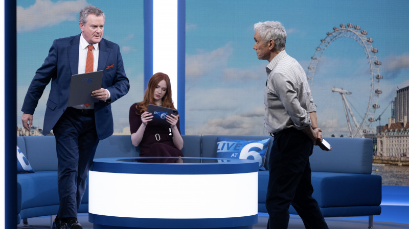   Douglas'ın kanepeden kalktığı sırada takım elbiseli Hugh Bonneville, Karen Gillan'ın bordo elbiseyle oturduğu, Madeline ve Ben Miles'ın ekose gömlek ve koyu renk pantolon giydiği ve Toby'nin Douglas'a doğru yürüdüğü Douglas İptal Edildi