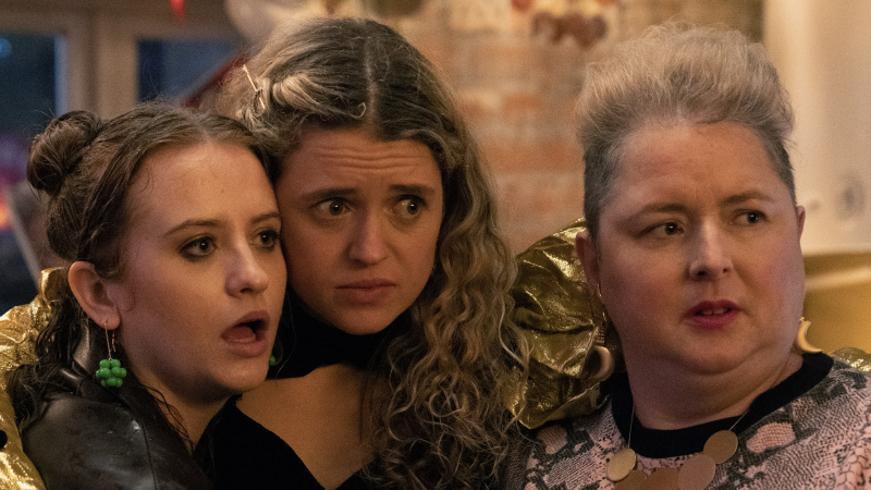  Η Jen (Máiréad Tyers), η Carrie (Sofia Oxenham) και η Mary (Siobhan McSweeney) φορώντας ρούχα για πάρτι μαζεύονται μαζί κοιτάζοντας κάτι που τους έχει σοκάρει στο Extraordinary.