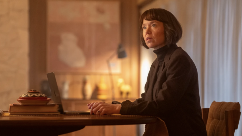   Anna Maxwell Martin Lucy Betts-Taylorina istumassa pöydän ääressä kannettavan tietokoneen kanssa Ludwigissa