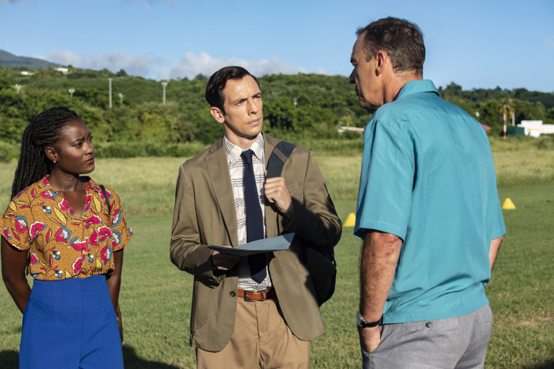   Na aerodromu, Naomi (Shantol Jackson) i Neville (Ralf Little) intervjuiraju Petera Holcrofta (Richard Lintern)