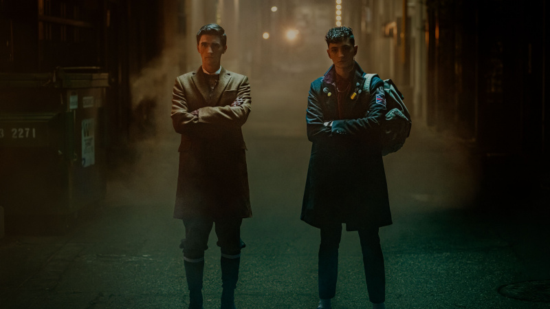 Edwin (George Rexstrew) ve Charles (Jayden Revri), Dead Boy Detectives'in 1. bölümünde karanlık bir ara sokakta duruyorlar.