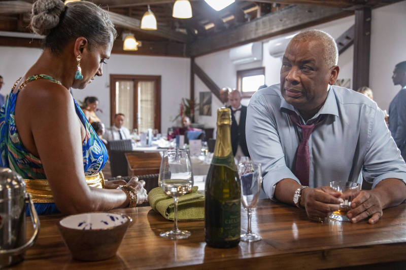   Jacqueline StClair (Cathy Tyson) stă la barul din Saint Marie Yacht Club, privind în jos nervoasă. Selwyn Patterson (Don Warrington) stă sprijinită de bar și se uită la ea cu îngrijorare.