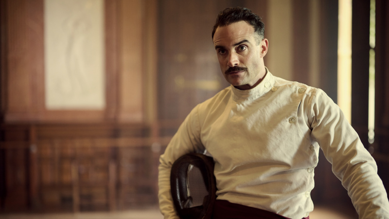   Joshua Sasse valges vehklemisjopes Oswald Mosley rollis filmis Outrageous.