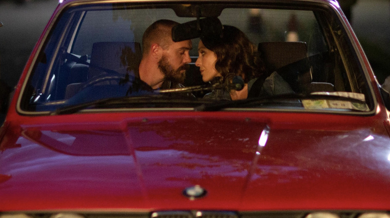   Alex (Sam Keeley) et Shiv (Roisin Gallagher) s'embrassent dans une voiture rouge dans The Dry.