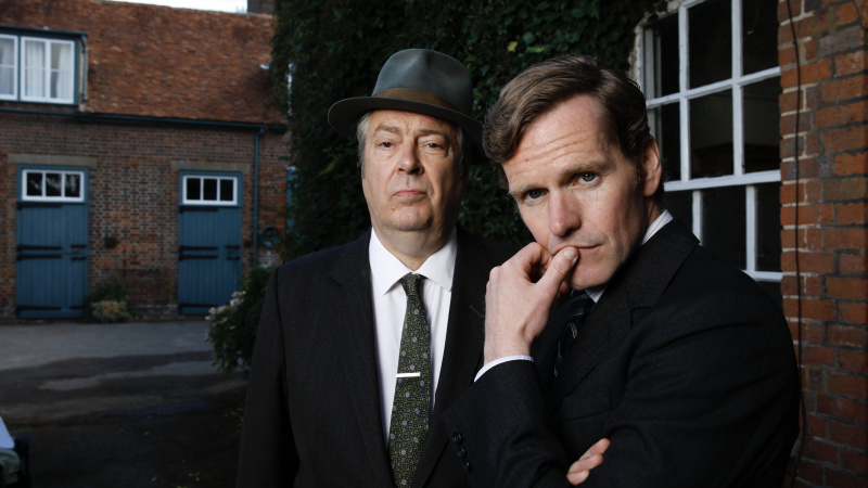   Roger Allam in einem dunklen Anzug und Hut als DCI Fred Thursday mit Shaun Evans in einem dunklen Anzug als DS Endeavour Morse in Endeavour.
