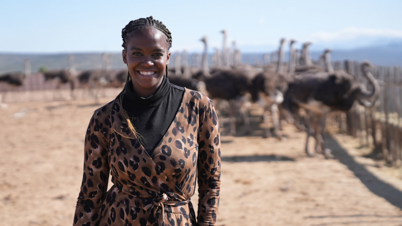   Oti Mabuse vestindo blusa com estampa de leopardo em frente à Oudtshoorn Ostrich Farm na África do Sul