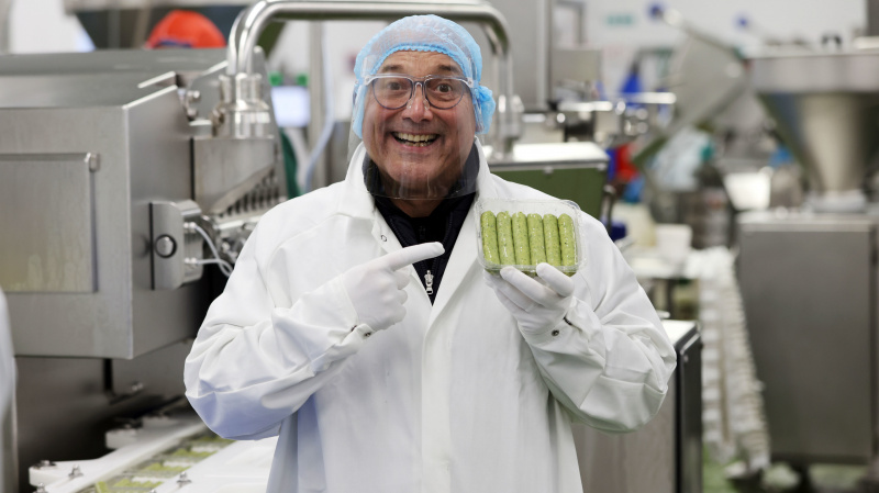  Gregg Wallace pose avec des saucisses végétaliennes dans Inside the Factory