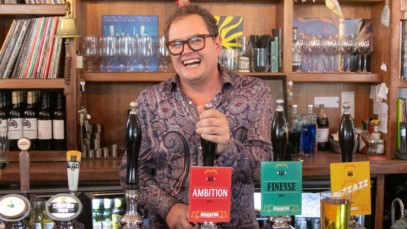   Alan Carr tire une pinte dans un bar pour les maîtres en design d'intérieur