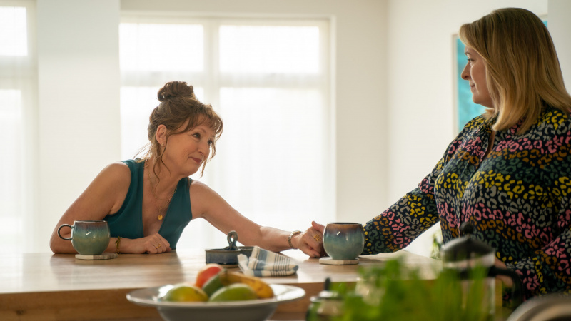   Η Susan Ryeland (Lesley Manville) κρατά την Katie Williams (Claire Rushbrook)'s hand in Magpie Murders