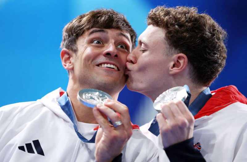  ผู้ชนะเลิศเหรียญเงิน Tom Daley และ Noah Williams จากทีมบริเตนใหญ่เฉลิมฉลองขณะที่พวกเขาโพสท่าหลังจากพิธีมอบเหรียญรางวัลการดำน้ำหลังจากการแข่งขันแพลตฟอร์ม 10 เมตรชายรอบชิงชนะเลิศในวันที่สามของการแข่งขันกีฬาโอลิมปิกที่ปารีส 2024