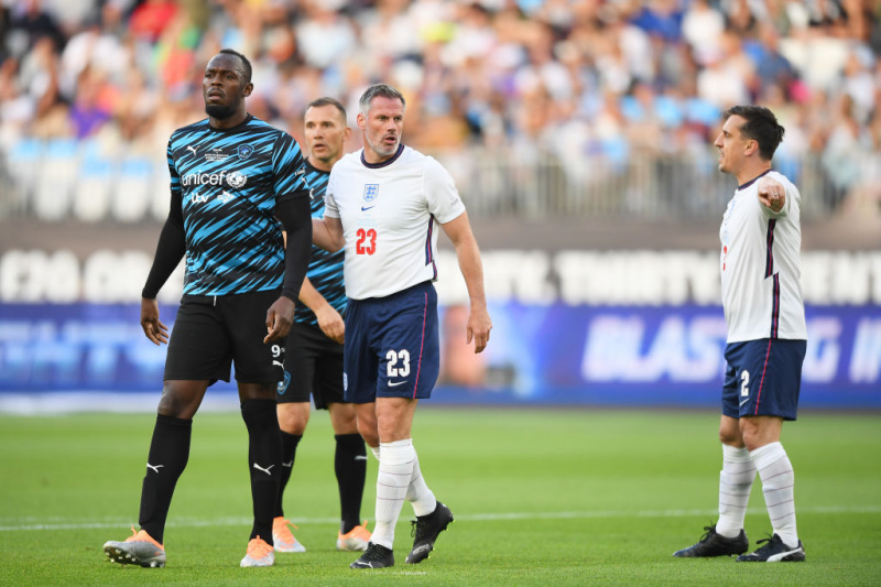   Gary Neville ve Jamie Carragher, Soccer Aid 2022'de Usain Bolt'u işaretliyor.