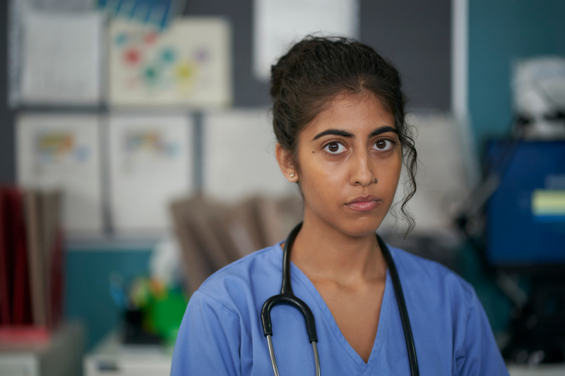  Priyanka Patel รับบทเป็น Dr. Ramya Morgan สวมหูฟังแพทย์และสครับสีน้ำเงิน