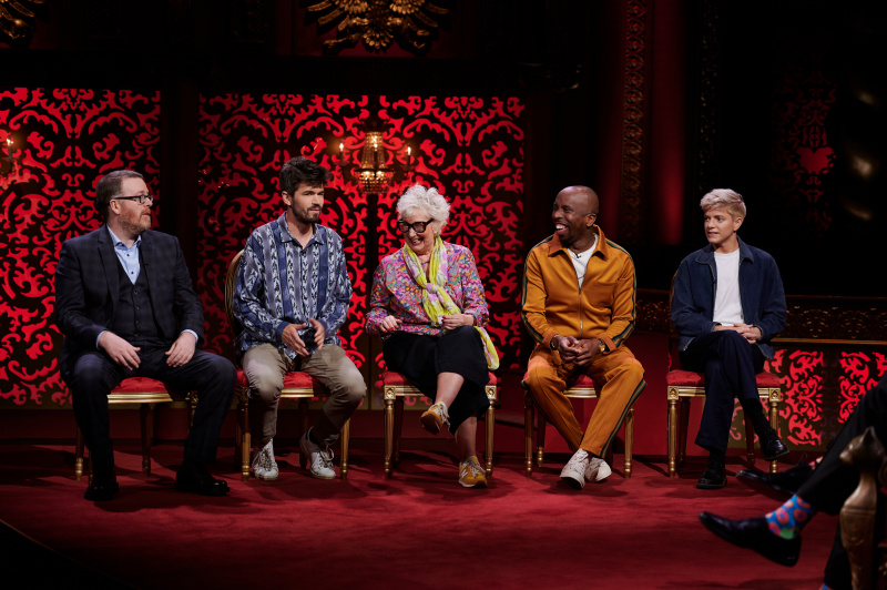  Актьорите от сезон 15 на Taskmaster на записа на епизод 1, седнали по азбучен ред на сцената: Франки Бойл, Иво Греъм, Джени Еклер, Кийл Смит-Байно и Мей Мартин