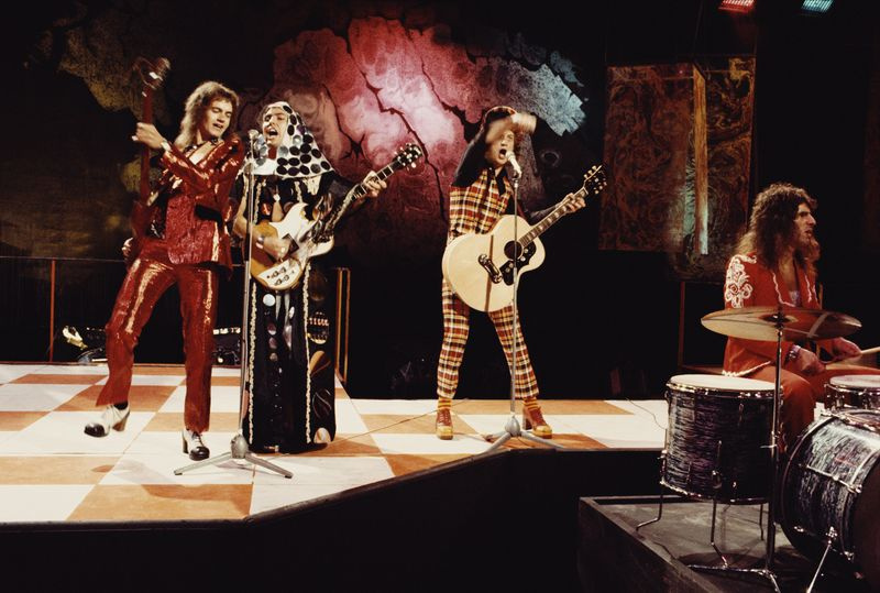 Ο Jim Lea λικνίζεται με τον Slade τη δεκαετία του 1970, φορώντας το διάσημο κόκκινο κοστούμι του.