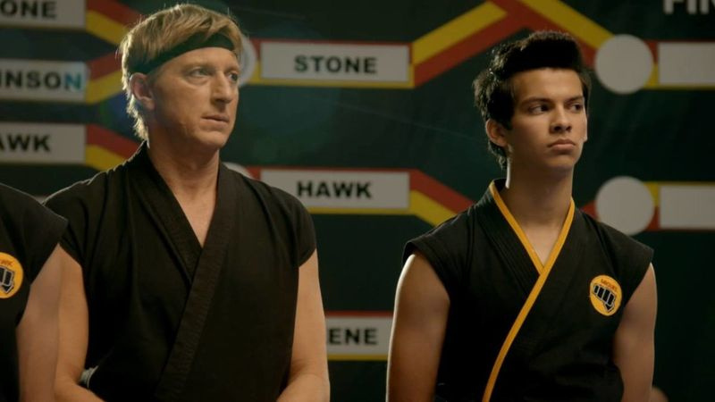 Johnny Lawrence (William Zabka) und Miguel Diaz (Xolo Maridueña) sehen bei einem Wettkampf zu.